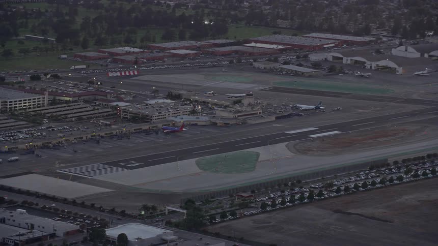 Aerial footage orbiting Burbank Airports runway and terminals at twilight in California