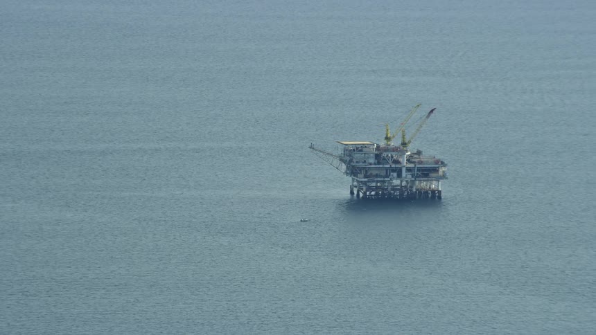 Aerial footage of an oceanic oil rig off the coast of Southern California during a partly cloudy day captured using a Shotover F1 by California Aerials