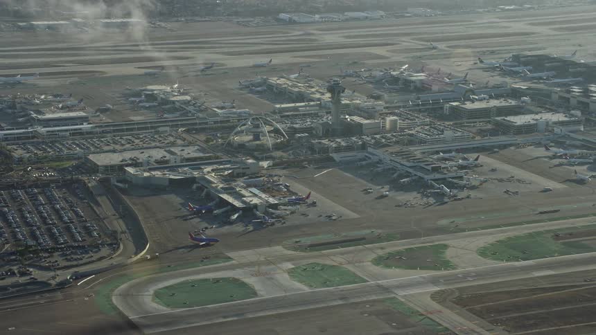 Aerial footage of the control tower and terminals at LAX Airport in California viewed from behind