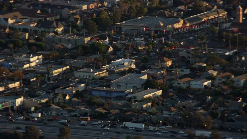 An LAPD helicopter tracks over heavy traffic on the I-10 freeway in Pico-Union Los Angeles captured in aerial stock footage