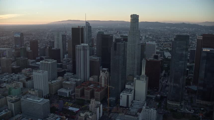 Approaching the Gas Company Tower and US Bank Tower at twilight in the bustling cityscape of Downtown Los Angeles California