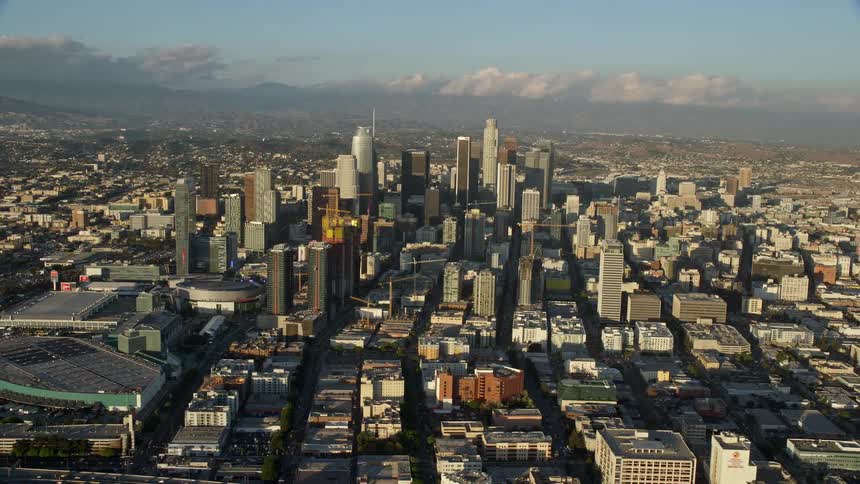 Aerial view of Downtown Los Angeles California from the interchange and convention center showcasing high-rise buildings and freeways shot during the day time with partly cloudy skies