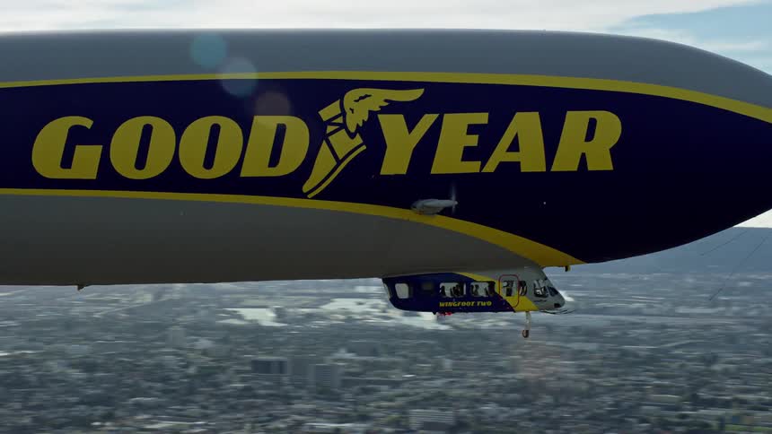 Aerial footage of the Goodyear Blimp flying over Long Beach California on a partly cloudy day during summer