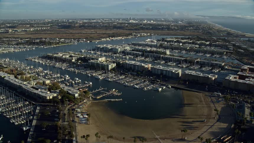 A stunning aerial view of waterfront apartment buildings overlooking marinas in Marina del Rey California on a partly cloudy day