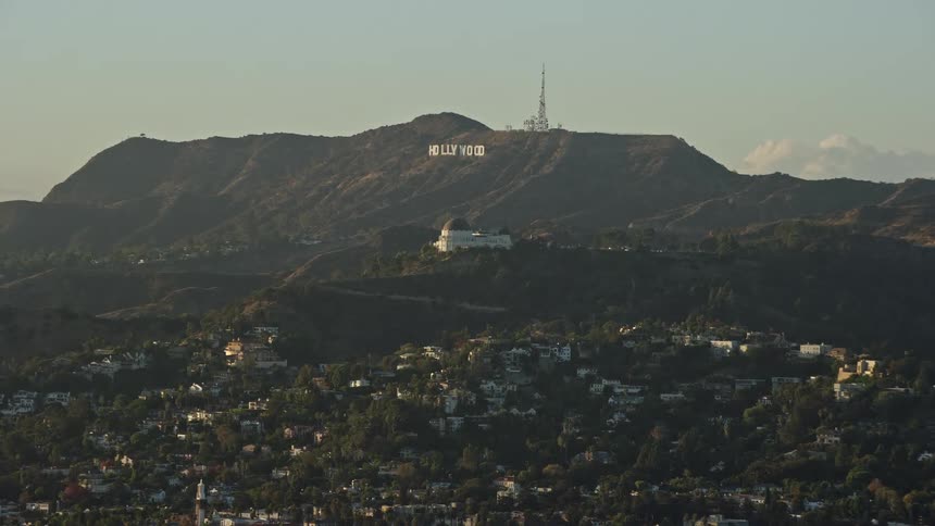 Aerial footage of the Hollywood Sign and Griffith Observatory in Los Angeles California on a partly cloudy day during summer shot from a Shotover F1 camera
