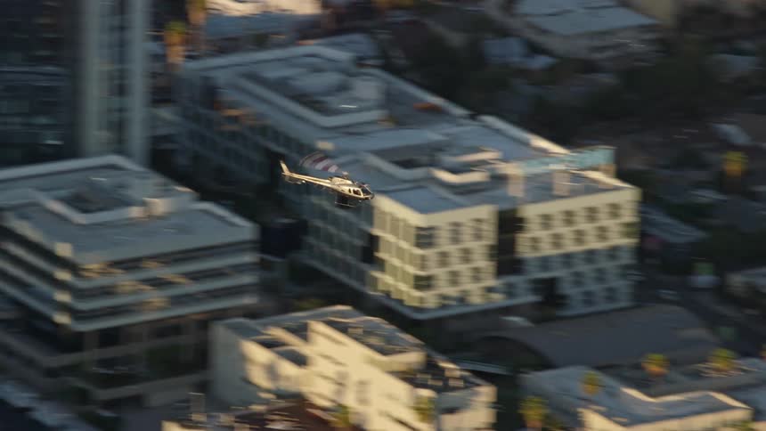 An LAPD helicopter flies over Hollywood CA in aerial footage during daytime