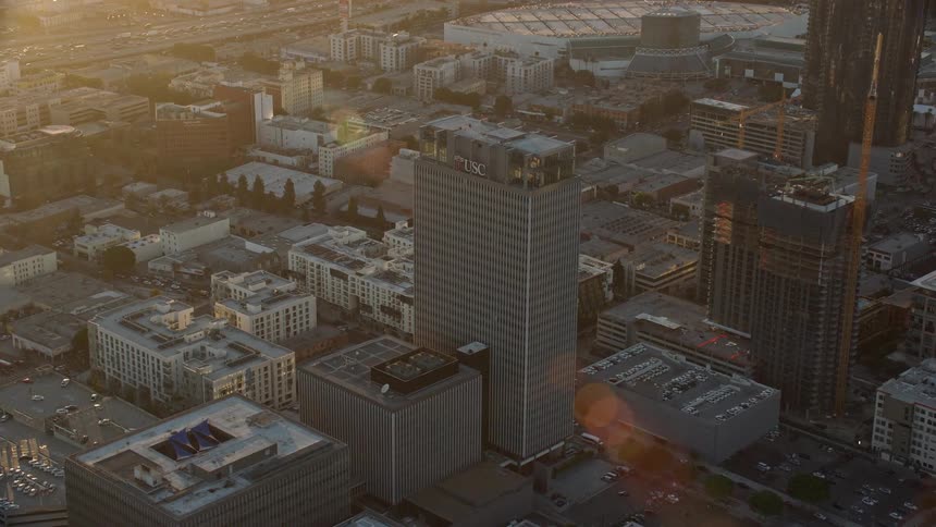 A stunning aerial view approaching the Transamerica Center at sunset in Downtown Los Angeles California amidst a partly cloudy and epic summer sky