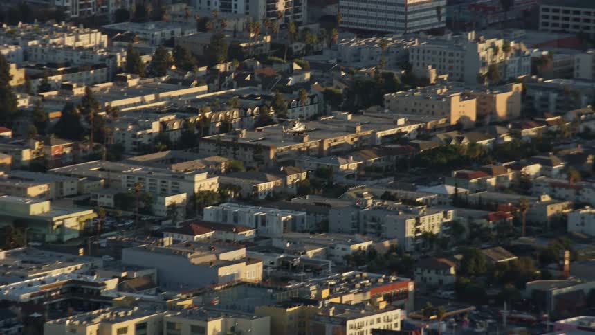 A LAPD helicopter flies over Hollywood and Koreatown in Southern California capturing the stunning aerial view of office and apartment buildings and residential areas during daytime