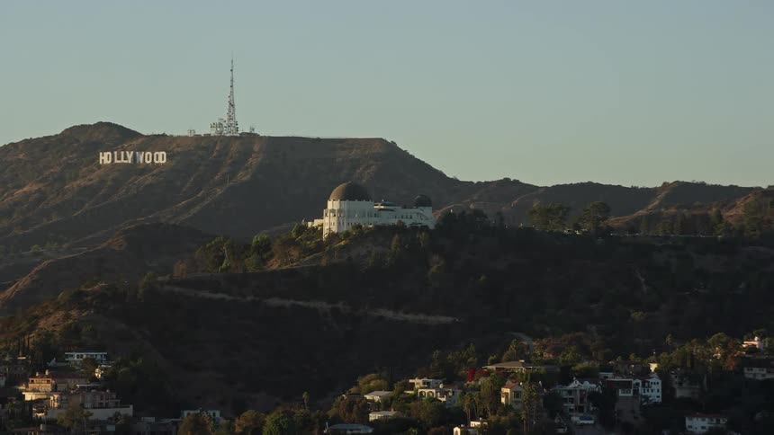 A stunning aerial view of Griffith Observatory and the iconic Hollywood Sign in Los Angeles California captured during a hazy day-time shot