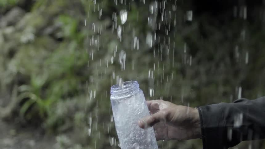 Person catches rainwater in a jug
