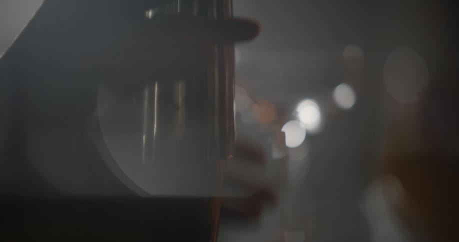 A bartender puts the top on a cocktail shaker to mix a drink