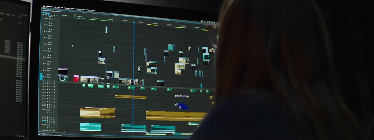 A woman uses video editing software on her computer