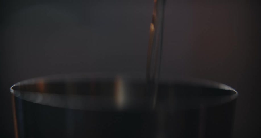 Pale transparent beverage is poured into a measuring cup