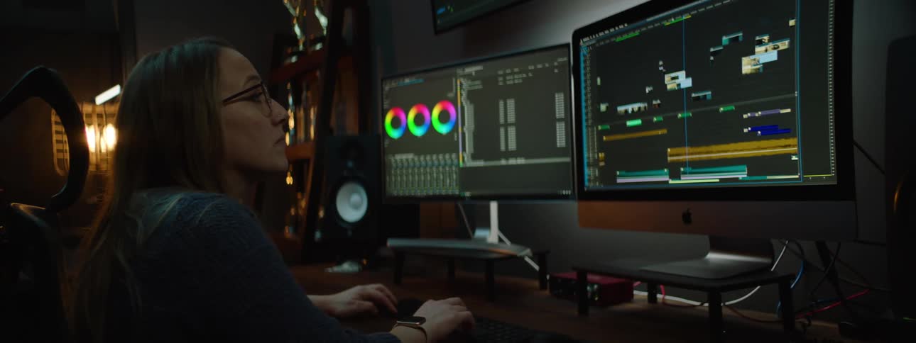 A woman uses video editing software on her computer