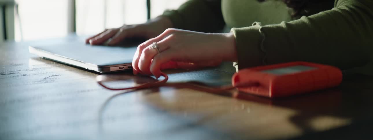 A woman is sitting at a table with her laptop