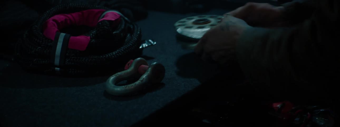 Person pulls hardware out of drawer onto workbench in dimly lit workshop