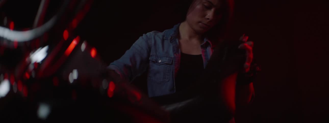 A woman is putting a cushion on her motorcycle