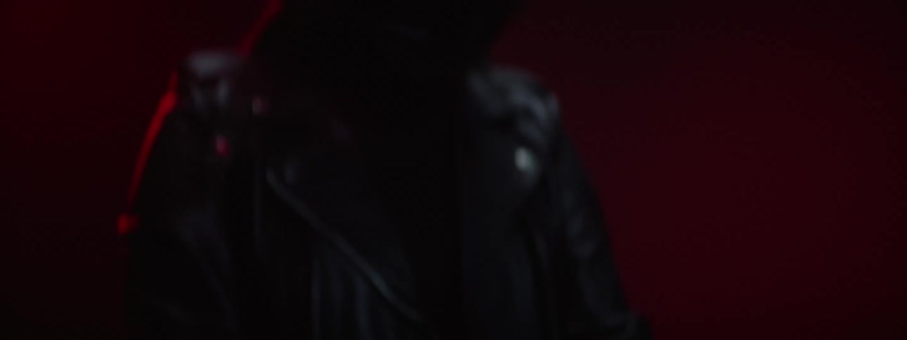 Female biker with black helmet and leather jacket puts on gloves on motorcycle