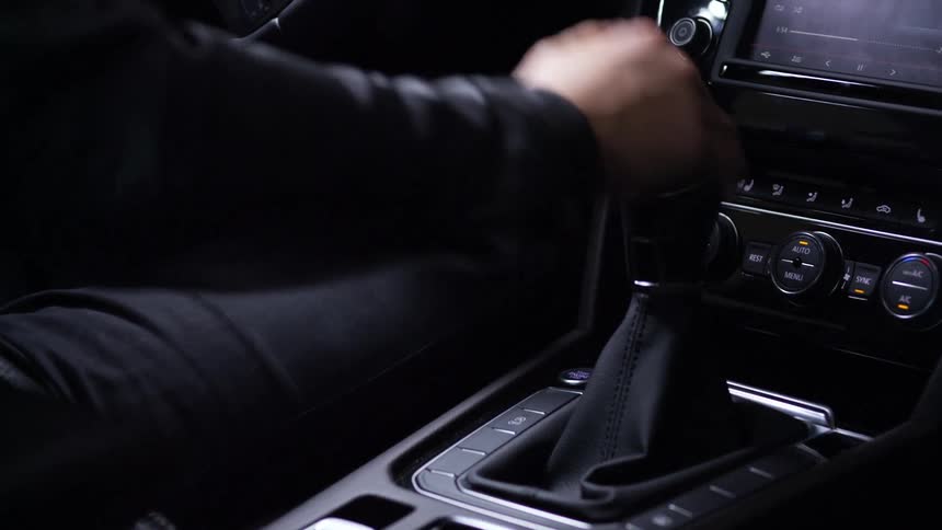 Person driving car shifts gears