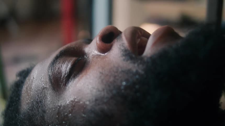 A man is laying down and looks tired while resting