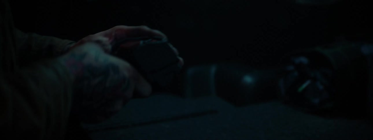 Man works on machinery in dark area lit by small light