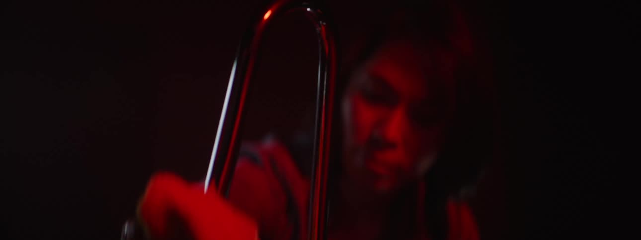 A woman is holding a white cloth and wiping down a chrome metal pipe