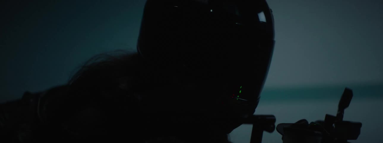 A close up of a woman riding a motorcycle with a full face helmet in all black