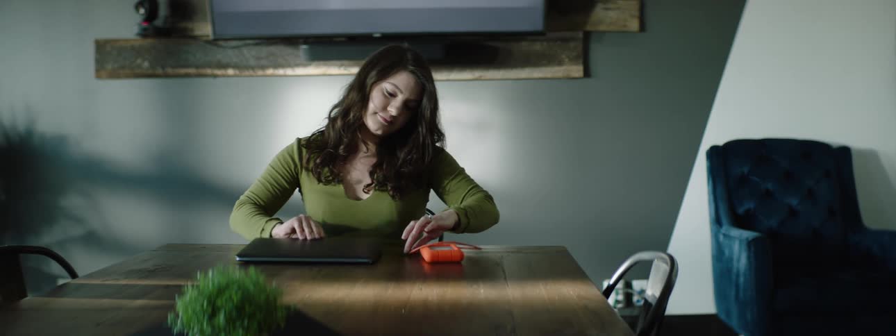 A woman is setting her laptop on the table