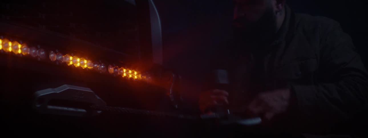 A person pulling a cable out of a truck