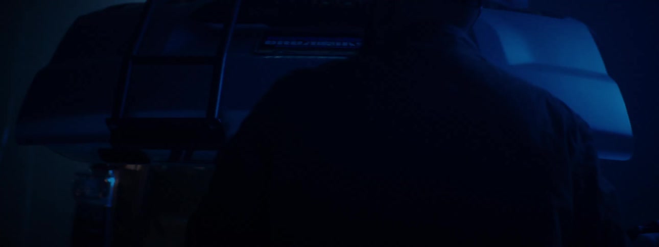 A man closes the hatch on his car in the dark
