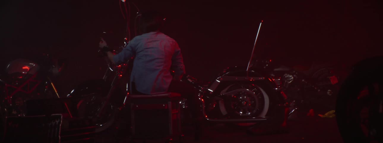 A person is fixing a motorcycle during the night time