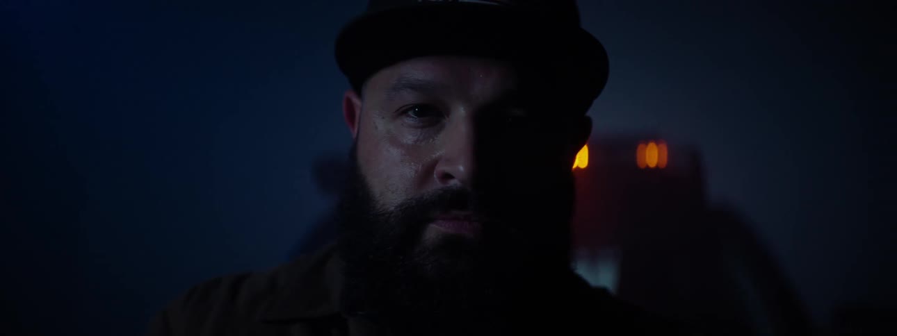 A close up of a mans face at night as a light bar on a vehicle turns on