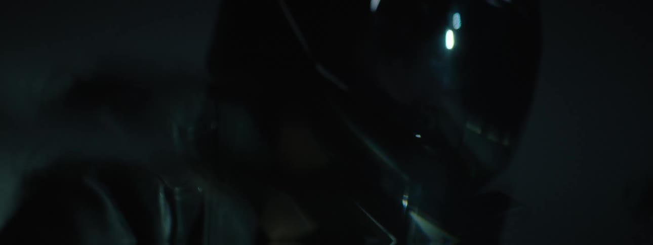 Flickering light shines across motorcyclist riding motorcycle at night