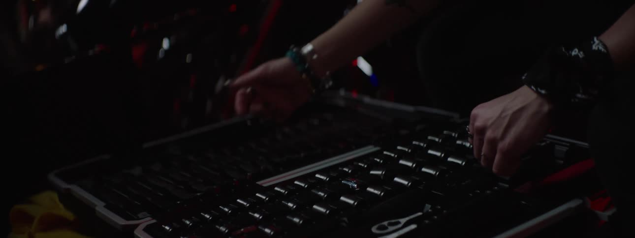 An up close of a woman using tools to work on a machine