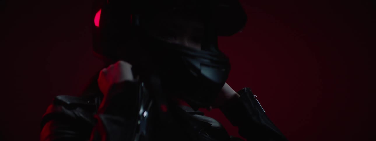 A close up of a woman putting on a motorcycle helmet as she is sitting on her bike