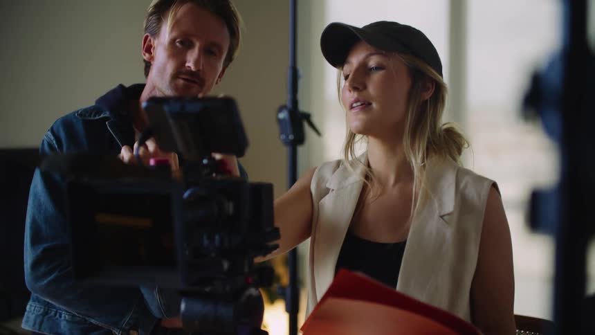A woman directs a video recording in a studio
