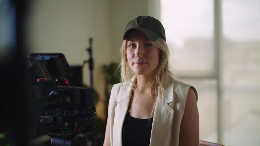 A woman standing behind a movie camera