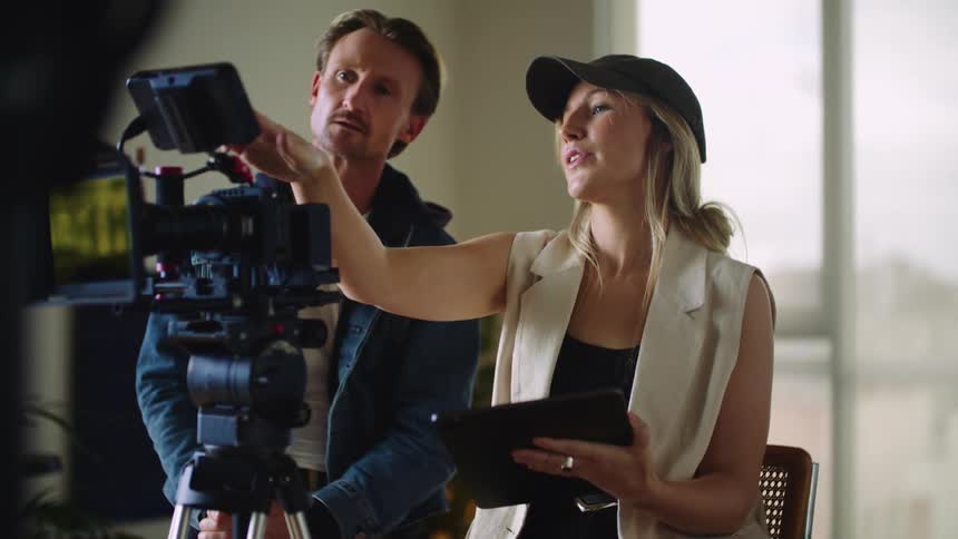 A female director discusses a camera shot with her male colleague
