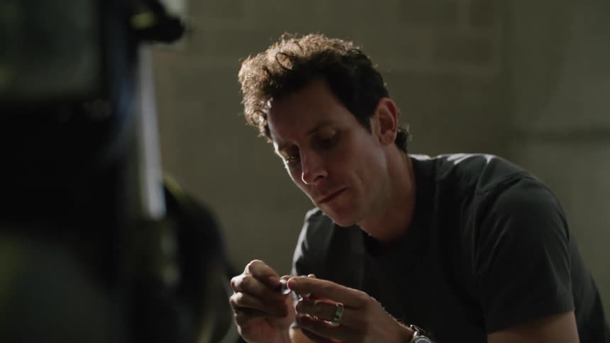 A mechanic holds a ratchet and turns a nut as he works on a motorcycle