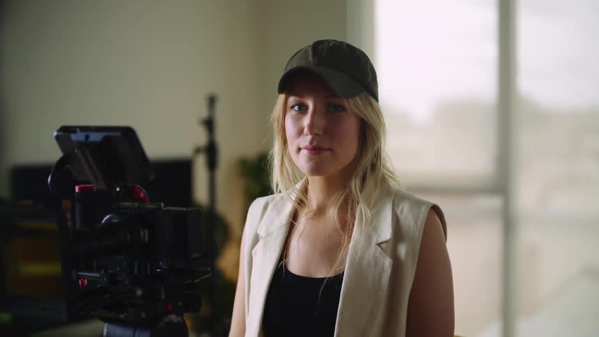 A woman standing around in a room in front of a camera