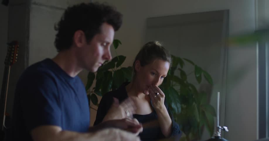 A woman teaches a man how to play the drums