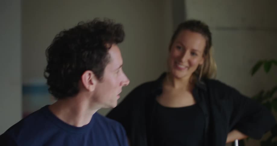 A woman claps along while a man plays the drums and high fives him afterward