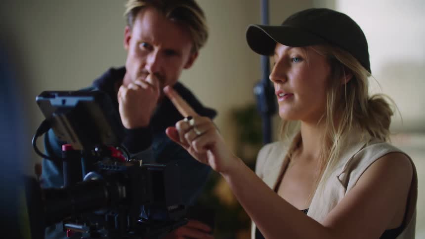 A director speaks with a man behind the camera
