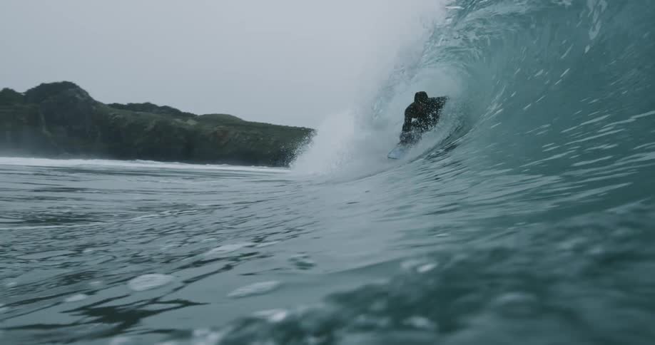 A man on a surfboard riding a wave on the ocean