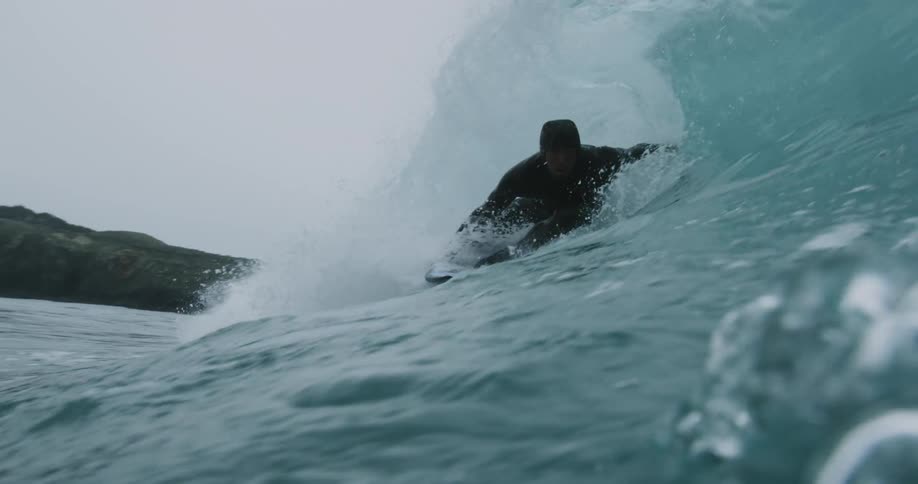 Man in wetsuit surfs waves off the coast