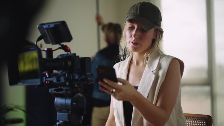 A woman working with a camera and phone