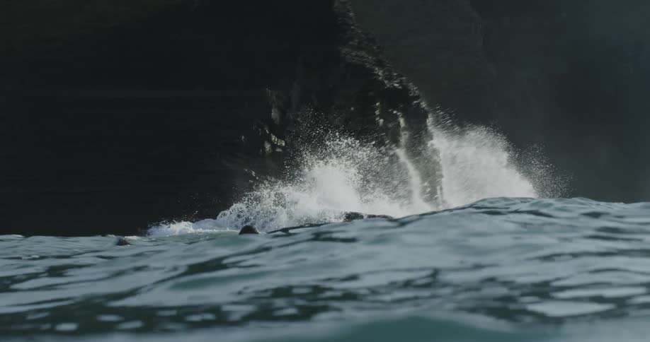 A man swims through strong waves in the ocean