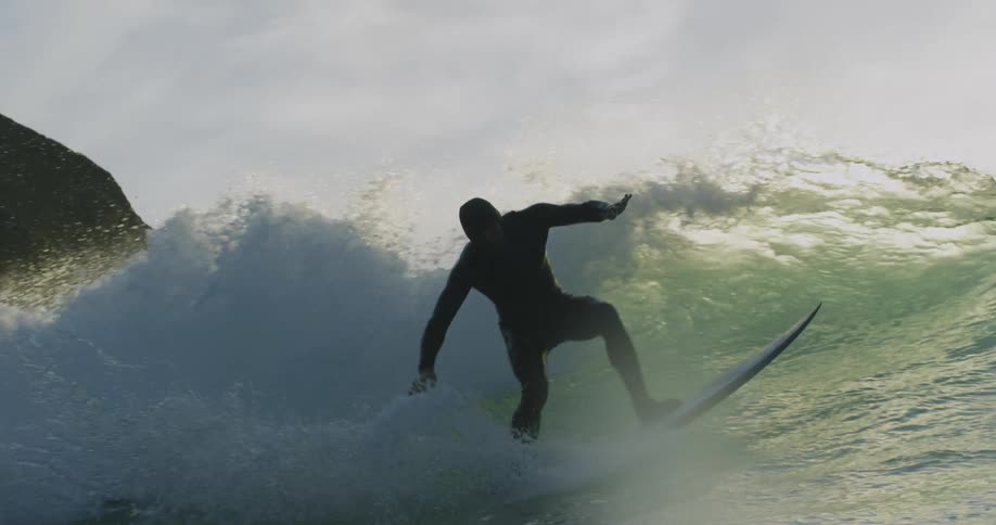 A man on a surf board riding a large wave through the ocean
