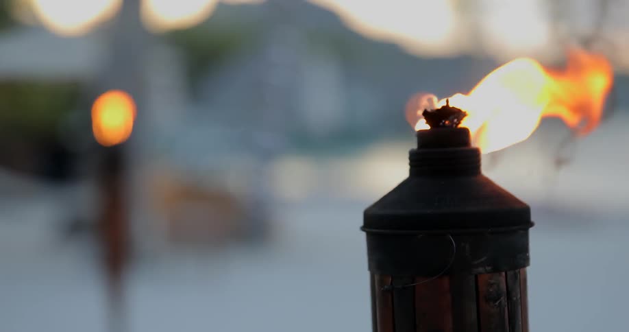 Two torches burn brightly on the beach
