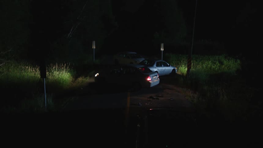 Vehicles sit with the blinkers flashing on a rural road
